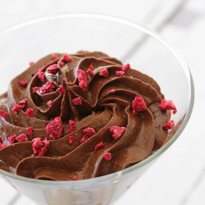 Kremete sjokolademousse i et martini-glass, toppet med frysetørket bringebær.