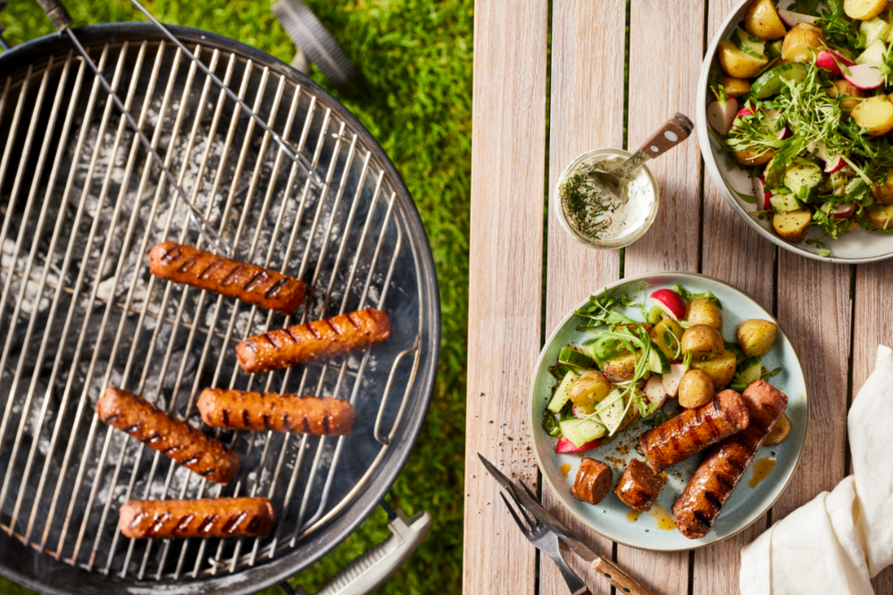 Beyondpølser griller, noen pølser er dandert på et fat med litt salat.