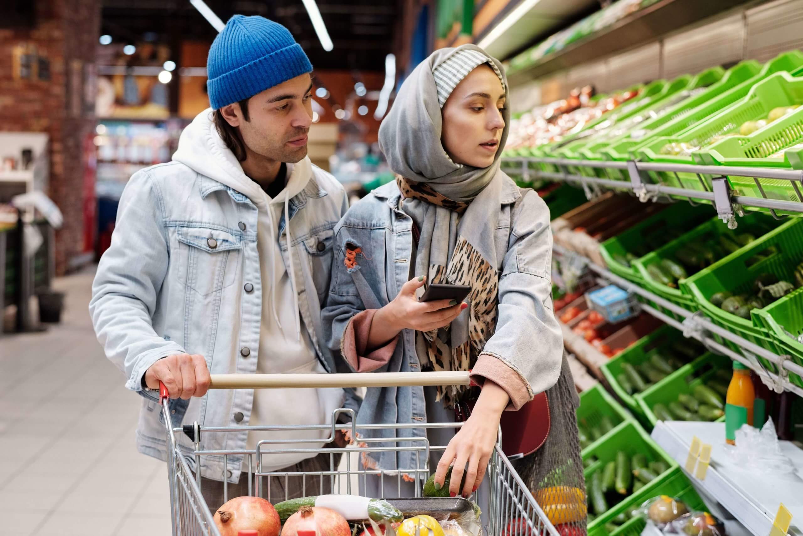 Et par handler sammen på butikken foran grønnsaksavdelingen.