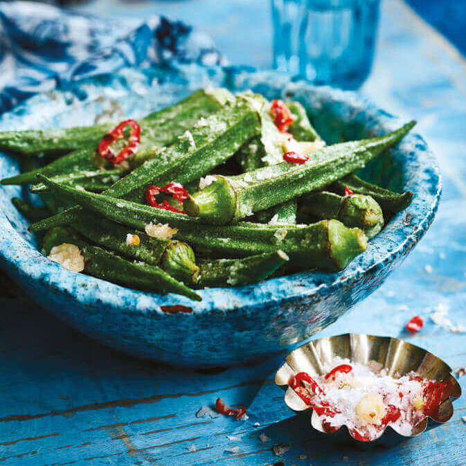 Friterte okra i en dyp skål drysset med havsalt og chili.