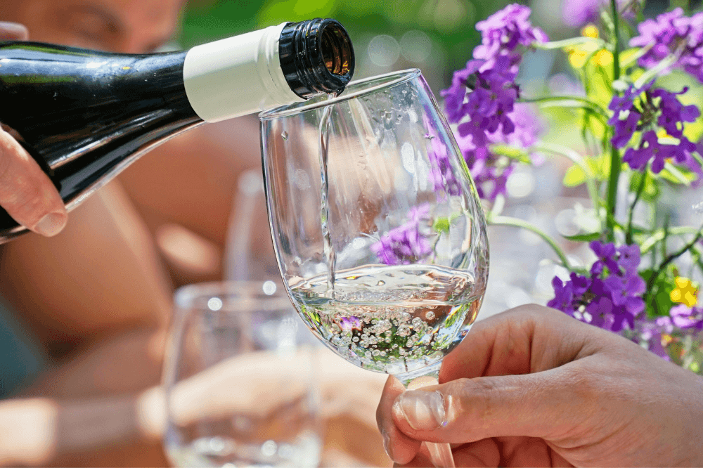 Hvitvin helles i et glass på en sommerdag.