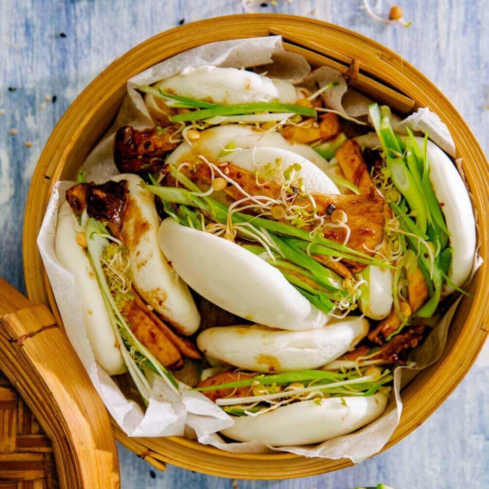 En bambus dampkoker fylt med hjemmelagde bao buns og digg fyll.
