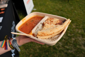 Hånd holder chana masala i takeaway-beger.