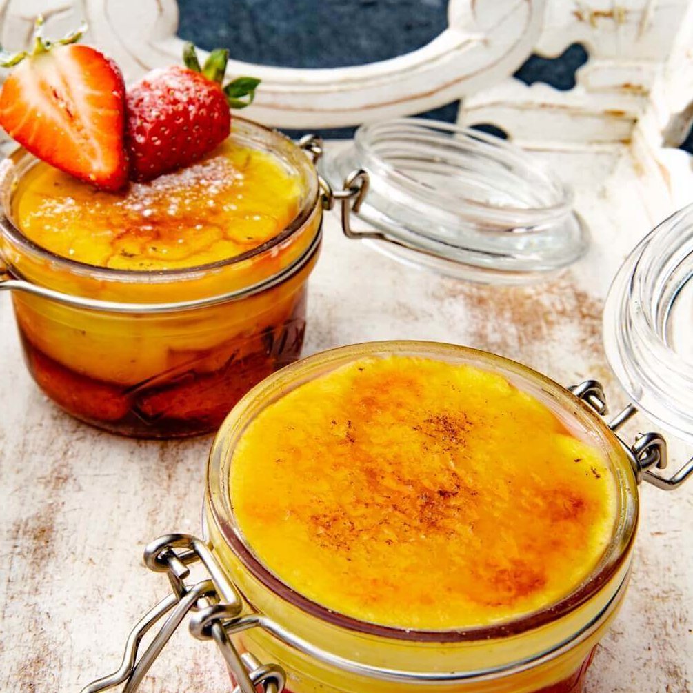 solgul creme brulee med jordbær og sprø sukkerskorpe i hengslede glass.