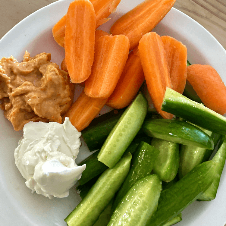 Gulrot og agurk skjært i staver med peanøttsmør og dip.