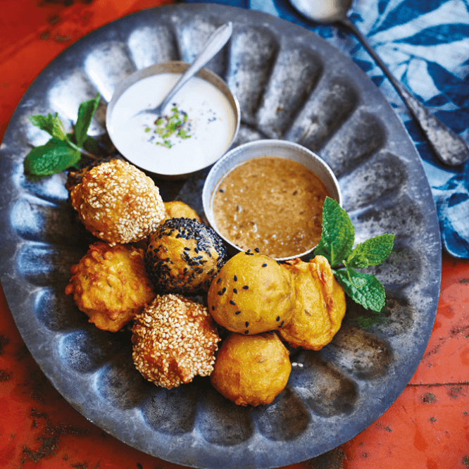 En tallerken med aloo bonda - potetboller med paprika, servert sammen med en chutney og vegansk raita.