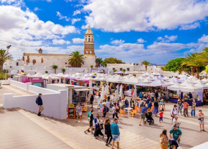 Bybildet fra Teguise på Lanzarote, mennesker samlet rundt et torg i byen. 