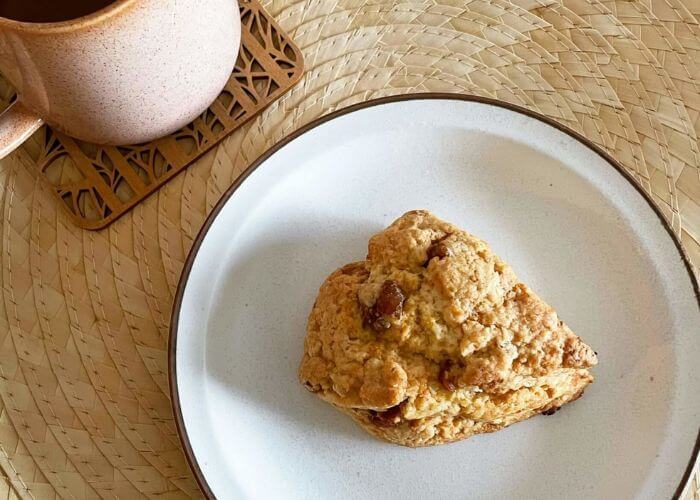 Fat med nybakt bringerbær-scone og rosa tekopp. 