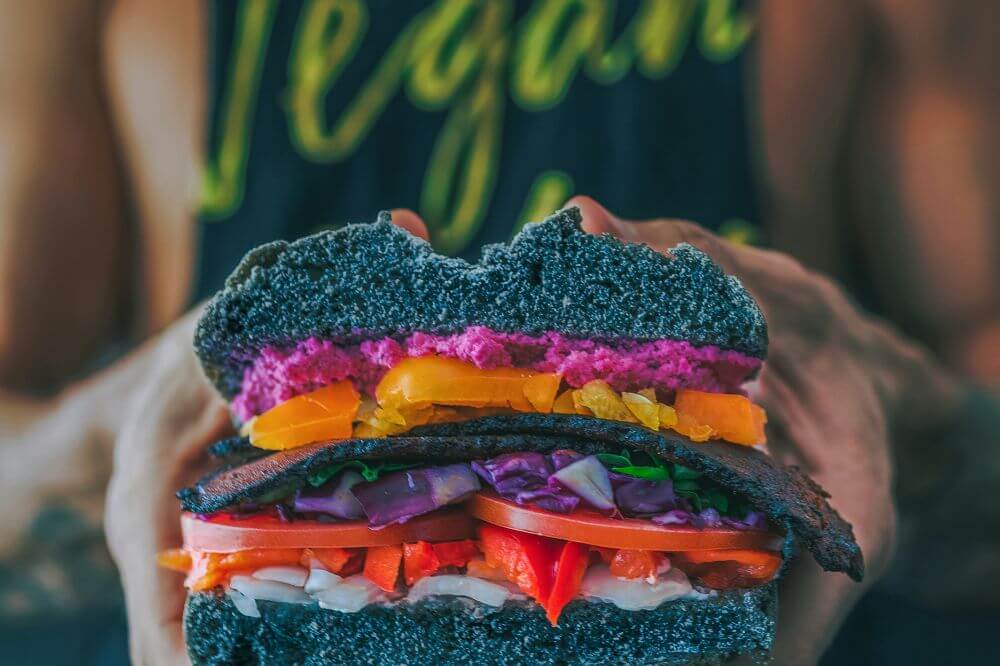 Ung kvinne som holder en vegetarburger.