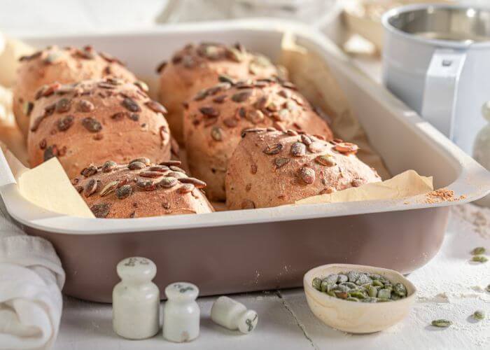 Nybakte rundtstykker med gresskarfrø på toppen. 