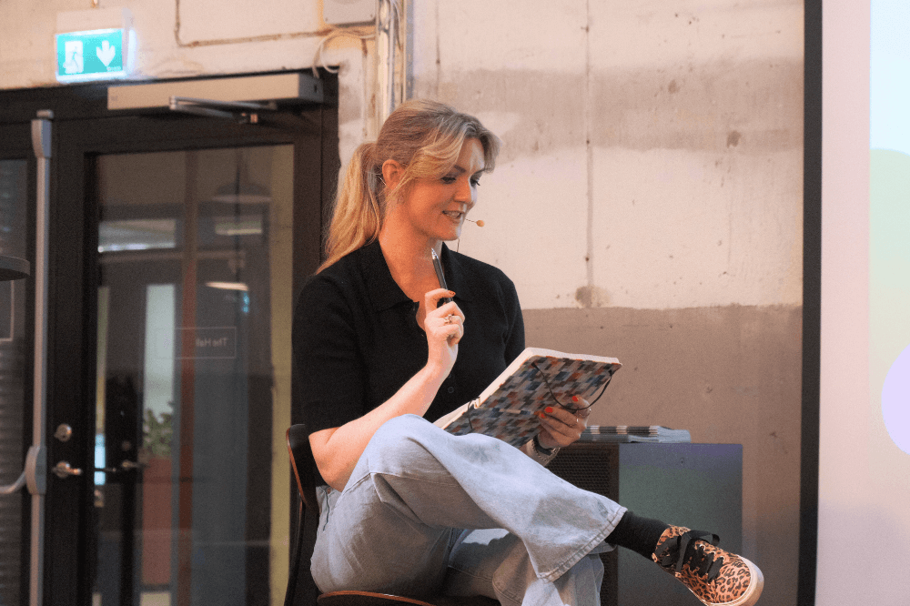 Hanne-Lene Dahlgren sitter på den stol og leser fra en notatbok.