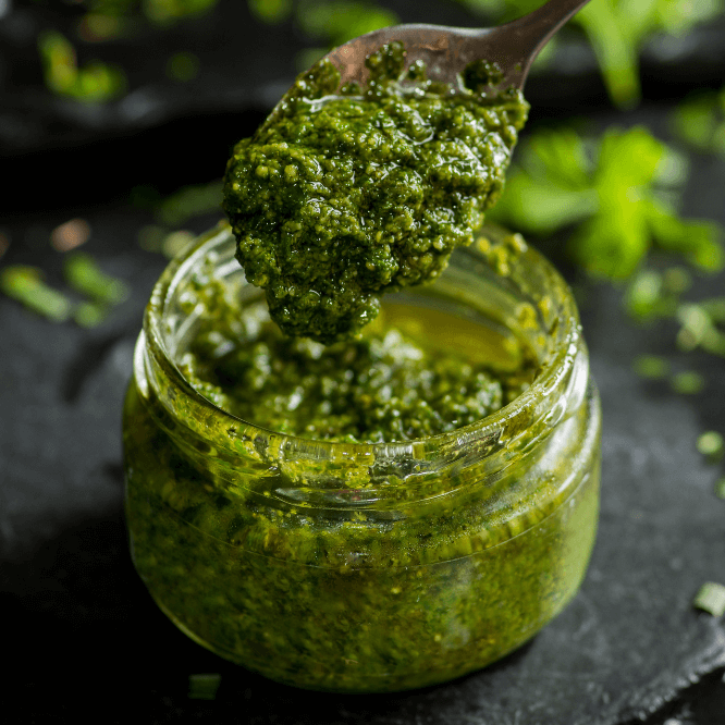 En krukke med grønn, vegansk pesto.