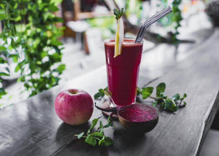 Ferskpresset smoothie med eple og rødbete i et glass.