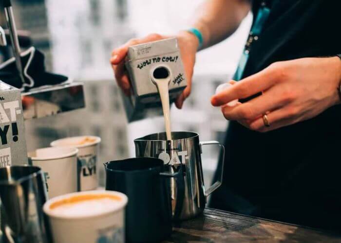 Barista varmer havremelk fra Oatly til å ha i kaffe.