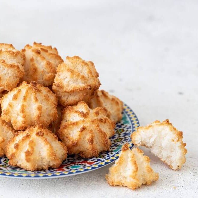 Et fargerikt fat med små , nystekte kokosmakroner.