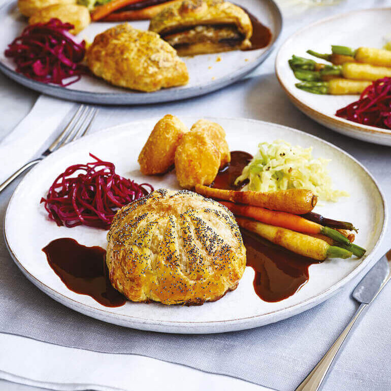 Sopp-wellington, stekte grønnsaker og saus ligger flott dandert på tallerkenen.